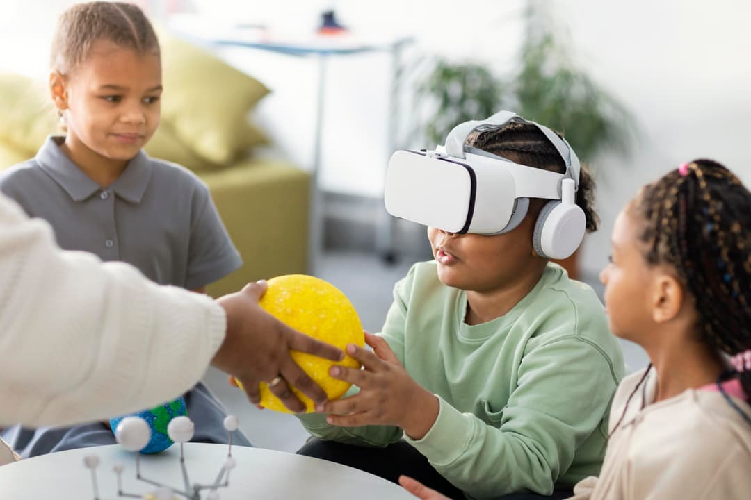 Children exploring science with VR and a solar system model